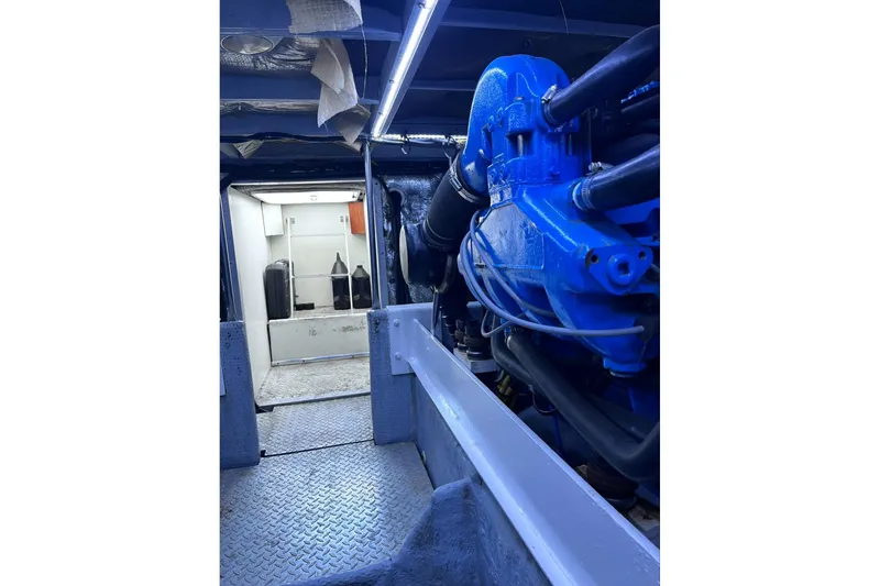 Slide: The Image of Engine room of a 2001 Silverton 42 Convertible yacht, featuring a blue engine. - 76