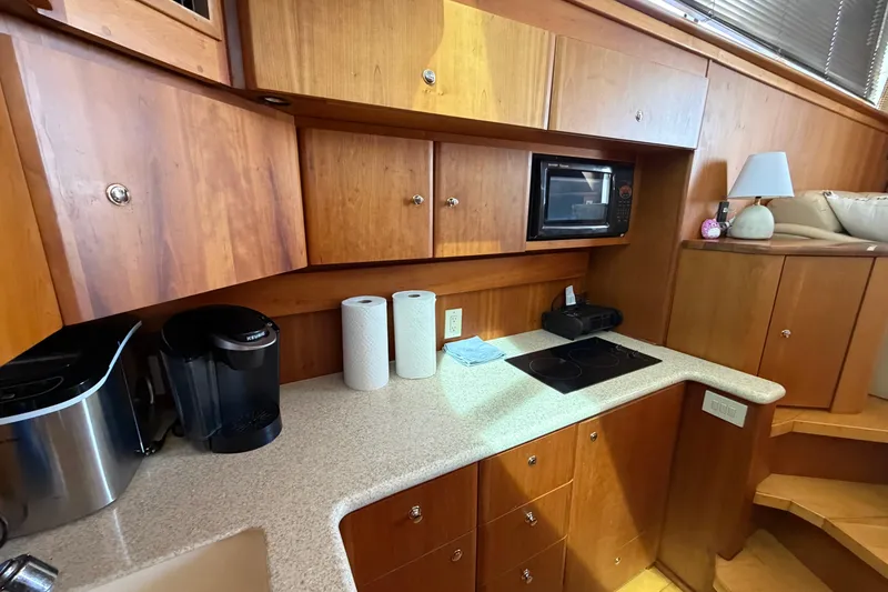 Slide: The Image of 2001 Silverton 42 Convertible yacht kitchen with wooden cabinets, appliances, and countertop. - 77