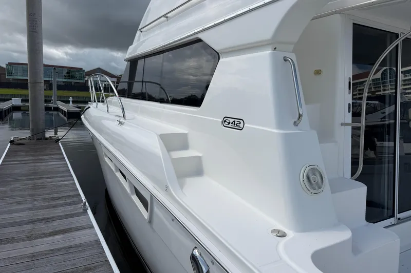Slide: The Image of 2001 Silverton 42 Convertible yacht docked at marina under cloudy skies. - 81