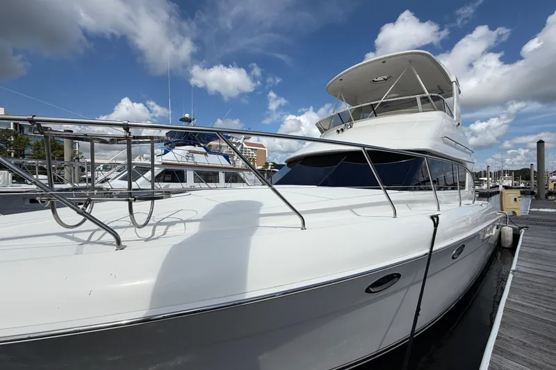 Slide: The Image of 2001 Silverton 42 Convertible yacht docked under a blue sky. - 82