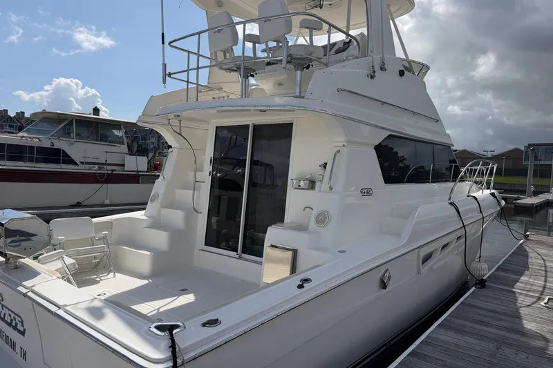 Slide: The Image of 2001 Silverton 42 Convertible yacht docked at marina under cloudy sky. - 83