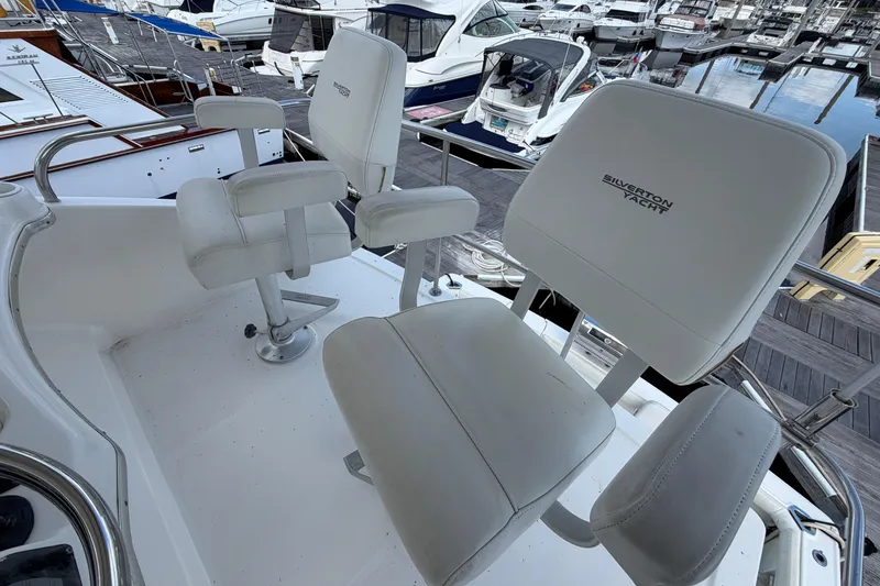 Slide: The Image of 2001 Silverton 42 Convertible yacht helm seats at marina dock. - 86