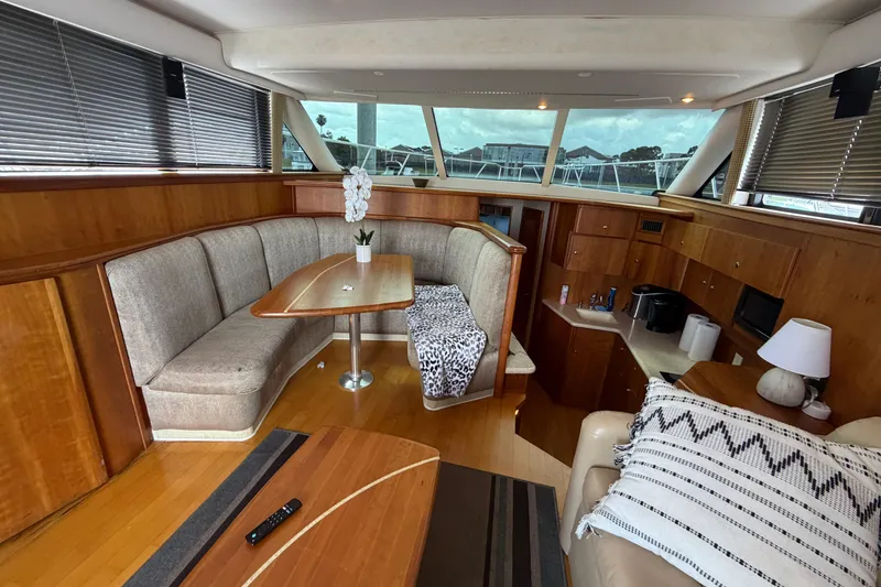 Slide: The Image of Interior of a 2001 Silverton 42 Convertible yacht with cozy seating and wooden finishes. - 95