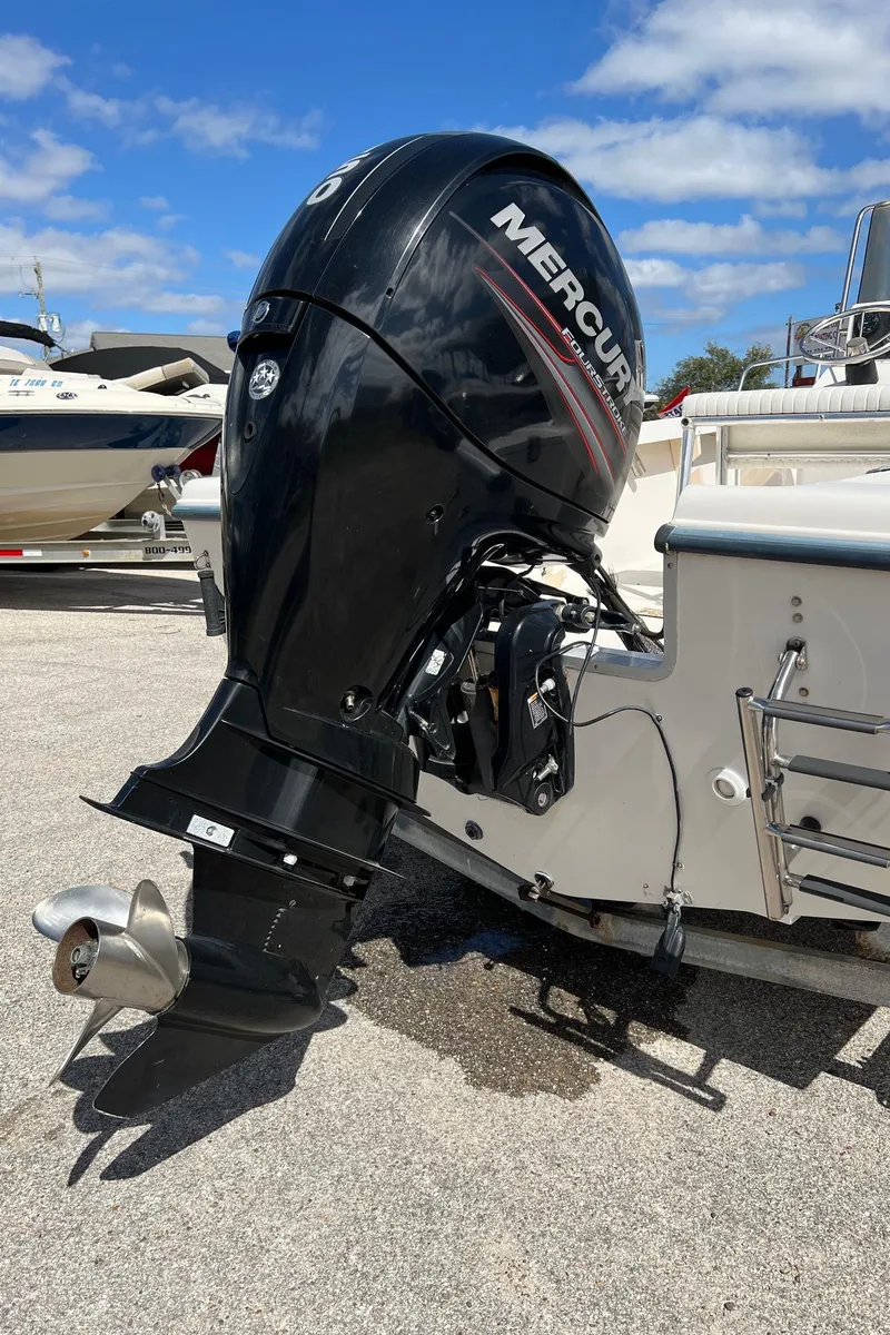 Slide: The Image of 1998 Sea Hunt 200 Triton boat with Mercury outboard motor, parked on a sunny day. - 7