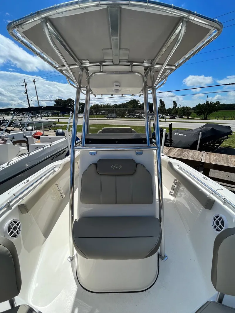 Slide: The Image of 2026 Key West 219 FS boat with T-top, seating, and open deck under a blue sky. - 5