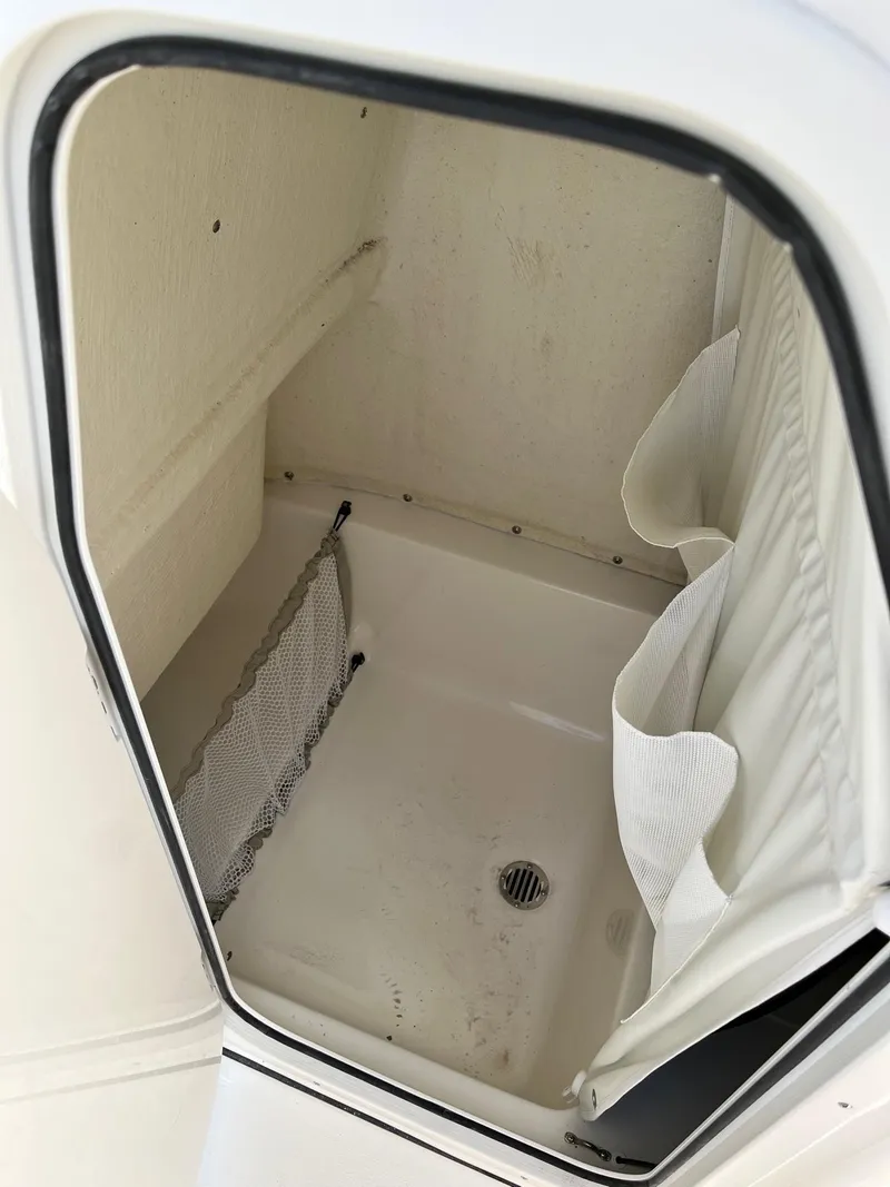 Slide: The Image of 2026 Key West 219 FS boat storage compartment with netting and drain. - 7
