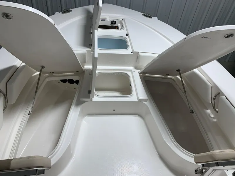 Slide: The Image of 2024 Robalo 246 Cayman boat with open storage compartments and seating. - 15