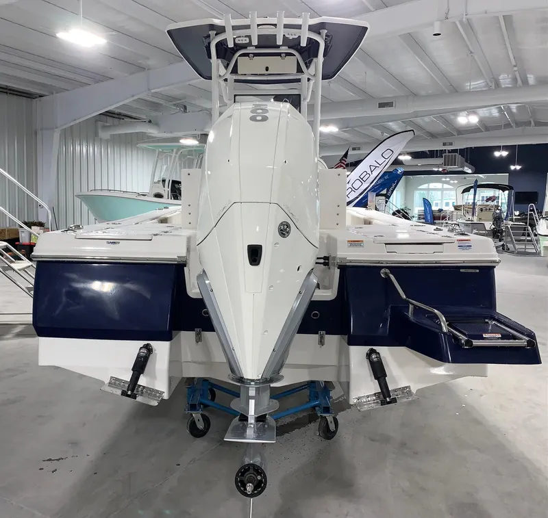 Slide: The Image of 2024 Robalo 246 Cayman boat displayed in a showroom, rear view. - 3