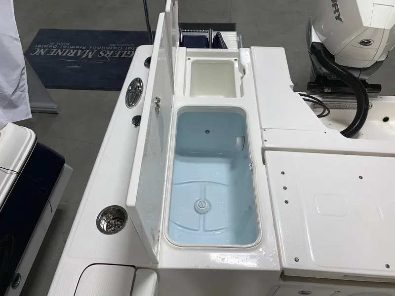 Slide: The Image of 2024 Robalo 246 Cayman boat with open storage compartments and Mercury outboard motor. - 8