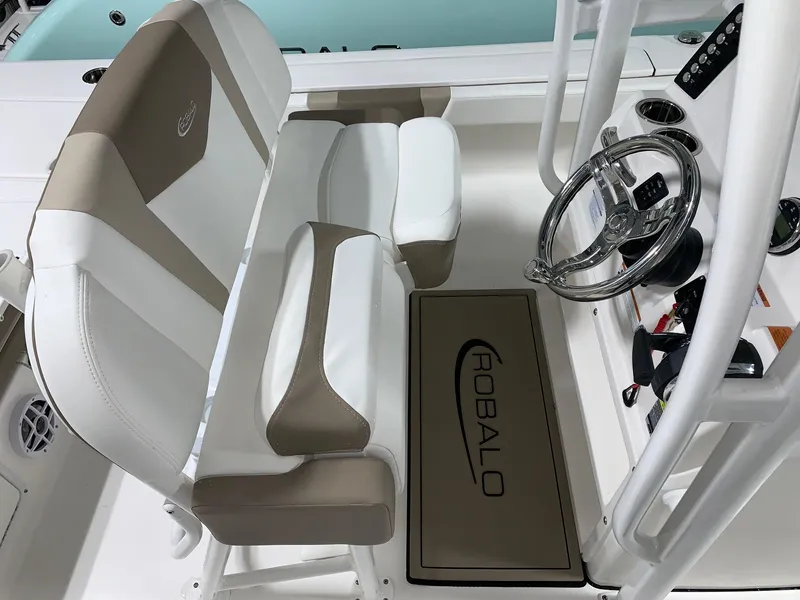 Slide: The Image of 2024 Robalo 246 Cayman boat interior with dual-tone seating and steering console. - 10