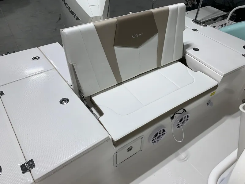 Slide: The Image of 2024 Robalo 246 Cayman boat seating area with storage compartments and speakers. - 13