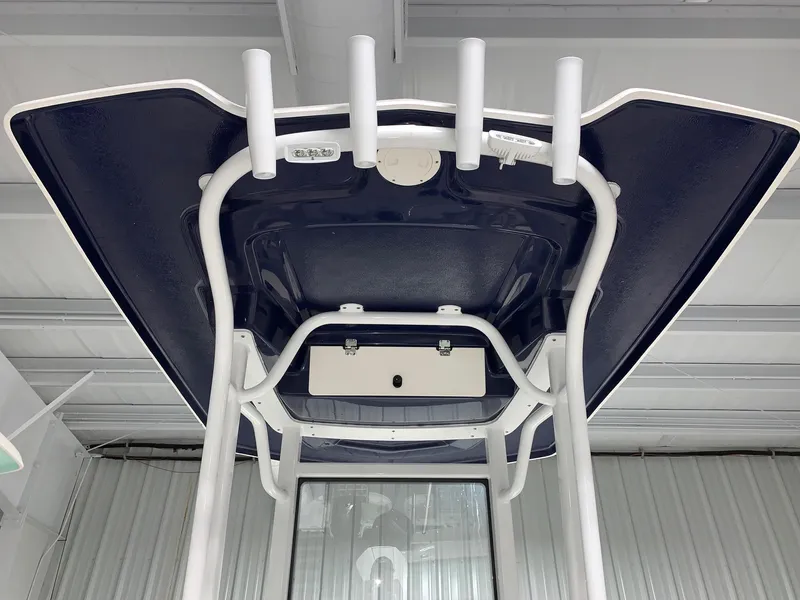 Slide: The Image of 2024 Robalo 246 Cayman T-top with rod holders in a showroom. - 16