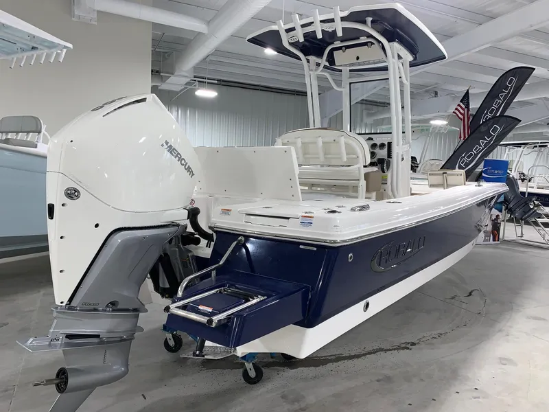 Slide: The Image of 2024 Robalo 246 Cayman boat with Mercury outboard motor in showroom. - 2