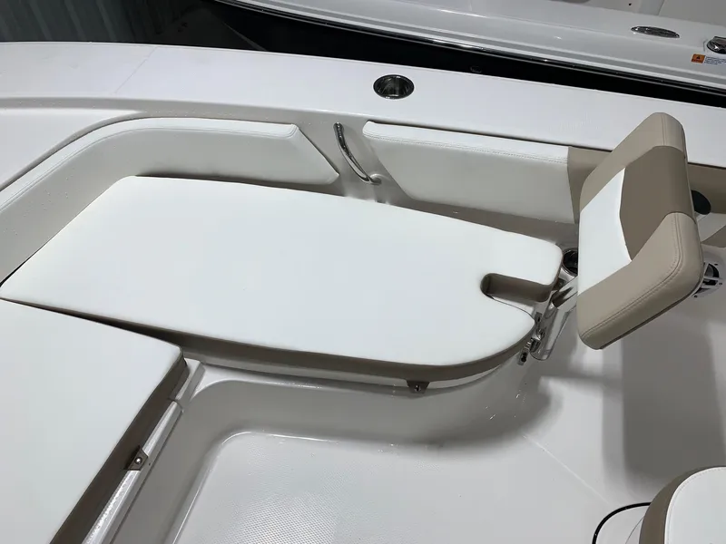 Slide: The Image of 2024 Robalo 246 Cayman boat interior with white cushioned seating. - 5