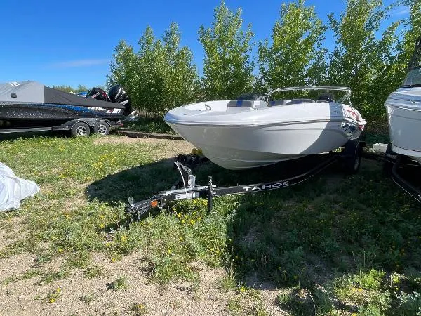 Slide: The Image of 2022 Tahoe T18 boat on a trailer in a grassy area. - 4