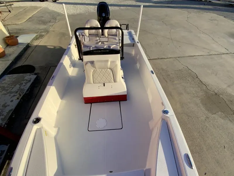 Slide: The Image of 2022 Blue Wave 2200 STL boat with Suzuki engine on trailer, parked outdoors. - 5
