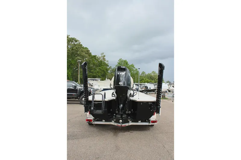 Slide: The Image of 2022 Blue Wave 2200 STL boat rear view, parked on a trailer, with overcast sky. - 8