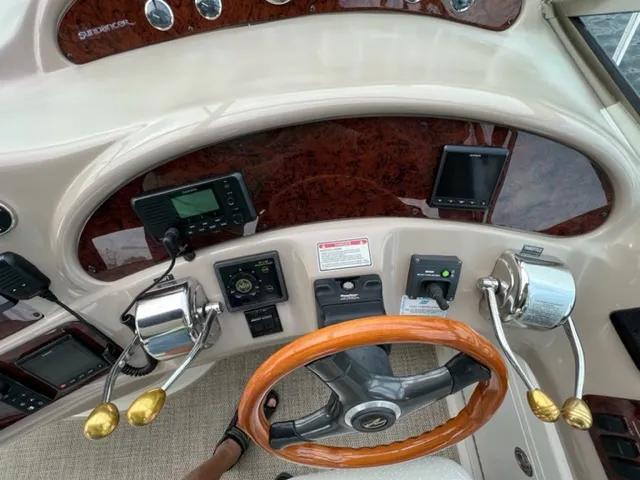 Slide: The Image of Helm of 2000 Sea Ray 460 Sundancer with wood steering wheel and control panels. - 10