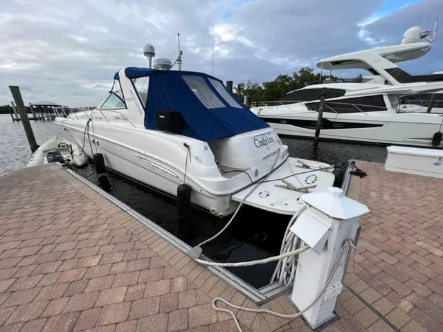 Slide: The Image of 2000 Sea Ray 460 Sundancer docked at marina with blue canvas cover. - 2
