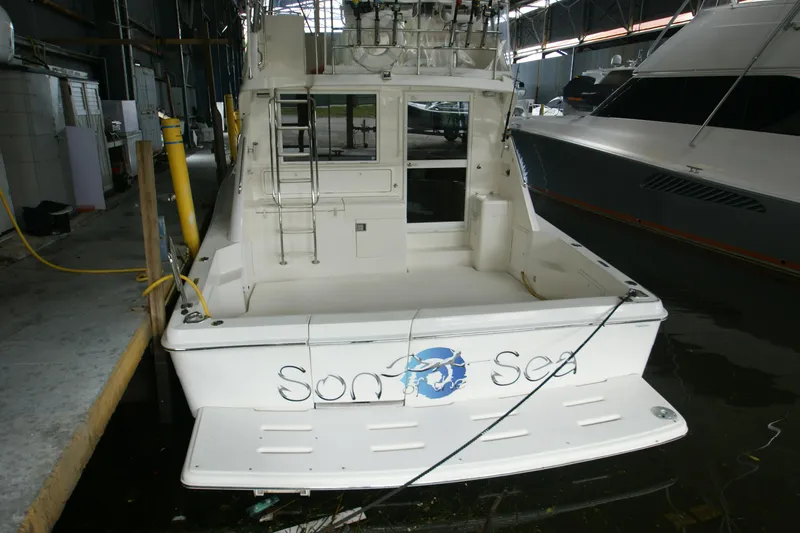 Slide: The Image of 2000 Riviera 48 Convertible docked, rear view of the boat. - 16