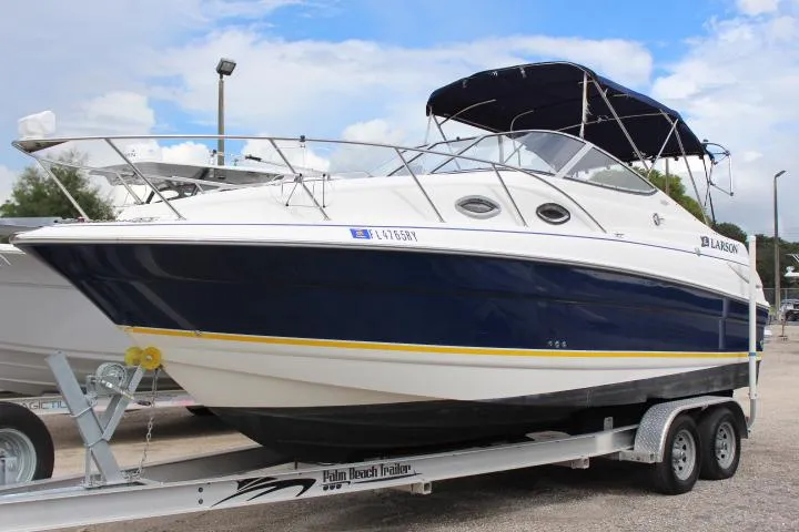 The Image of 2005 Larson Cabrio 240 boat on a trailer, blue and white exterior. - 0