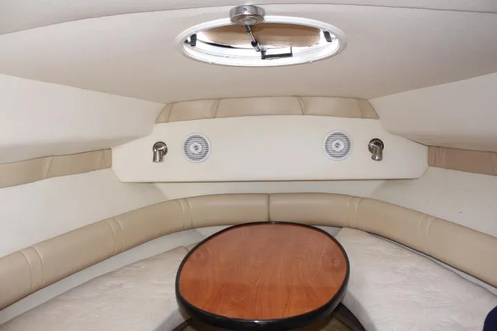 Slide: The Image of Interior cabin of 2005 Larson Cabrio 240 boat with round table and seating. - 10