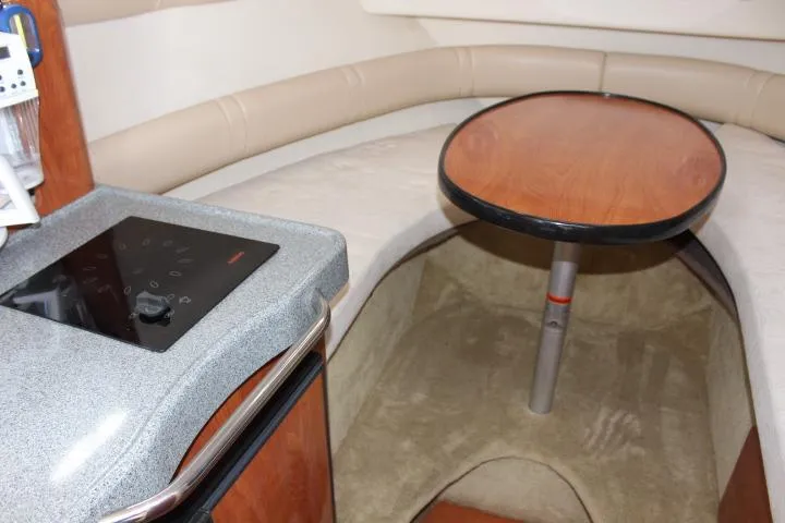 Slide: The Image of Interior of 2005 Larson Cabrio 240 boat with table and kitchenette. - 11