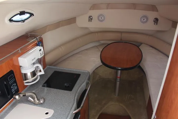 Slide: The Image of Interior of 2005 Larson Cabrio 240 boat with kitchenette and seating area. - 13