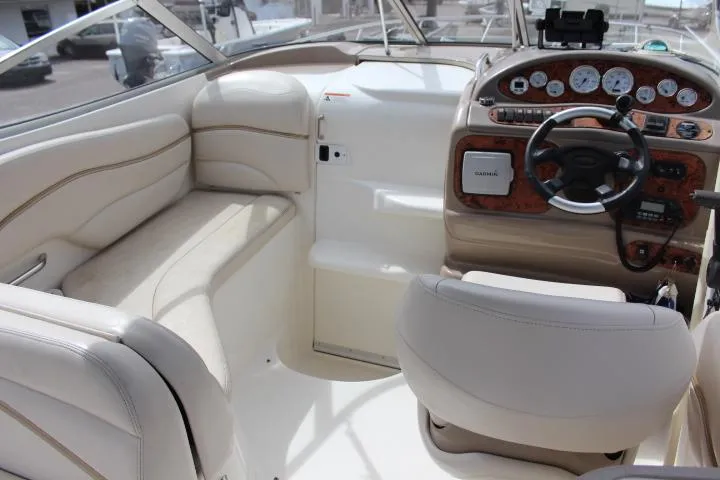 Slide: The Image of Interior of a 2005 Larson Cabrio 240 boat with beige seating and a detailed dashboard. - 15