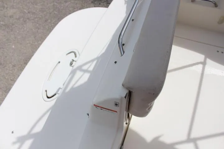 Slide: The Image of 2005 Larson Cabrio 240 boat deck with white seating and storage hatch. - 20