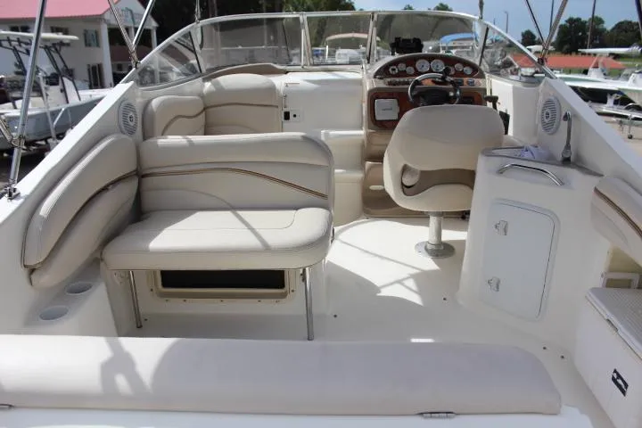 Slide: The Image of 2005 Larson Cabrio 240 boat interior with beige seating and control panel. - 21