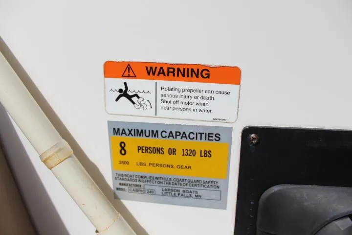 Slide: The Image of Warning and capacity labels on a 2005 Larson Cabrio 240 boat. - 24