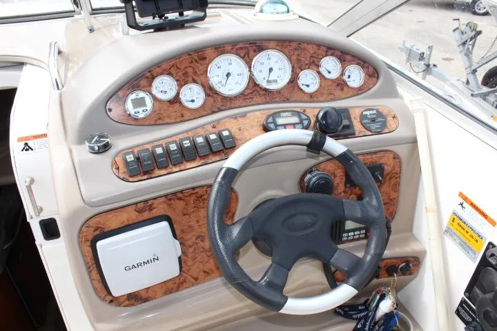 Slide: The Image of 2005 Larson Cabrio 240 boat dashboard with Garmin GPS and woodgrain finish. - 6