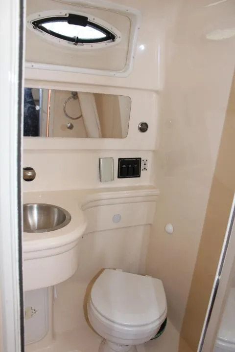 Slide: The Image of Compact bathroom in a 2005 Larson Cabrio 240 boat with sink, toilet, and mirror. - 7