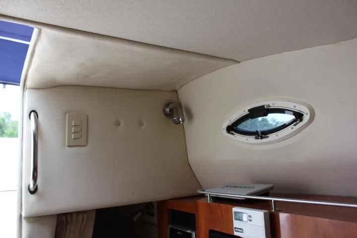 Slide: The Image of Interior cabin of a 2005 Larson Cabrio 240 boat with a small window. - 8