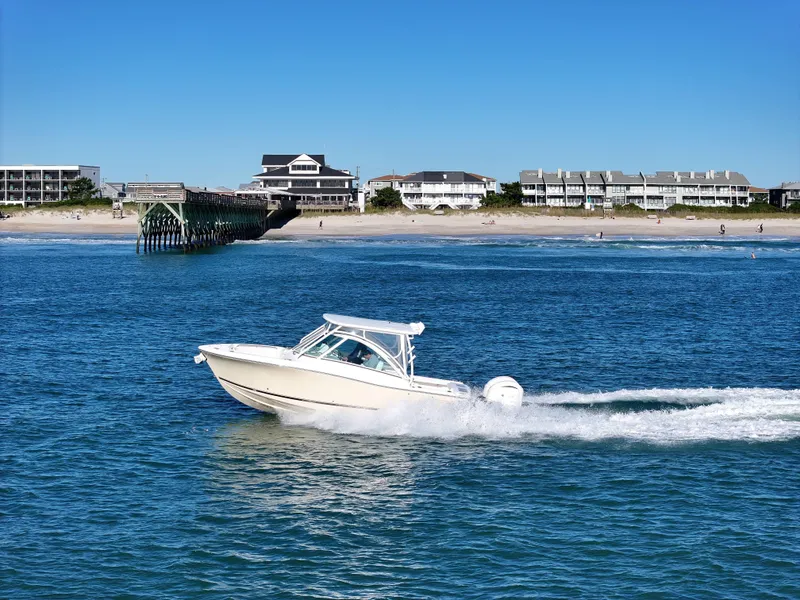 Slide: The Image of 2022 Albemarle 27 DC boat cruising on a calm river under clear blue skies. - 1