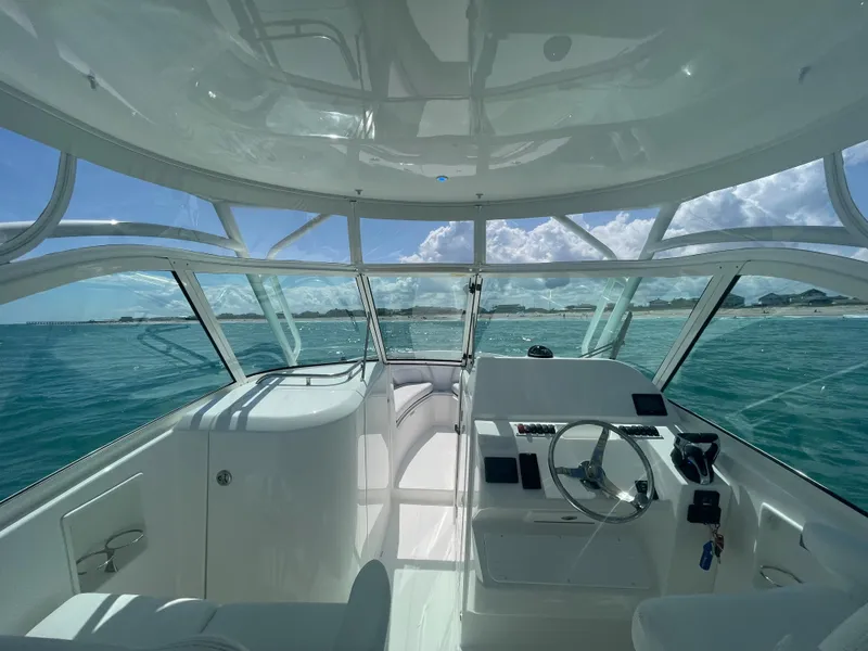 Slide: The Image of 2022 Albemarle 27 DC boat cruising on open water under a partly cloudy sky. - 12