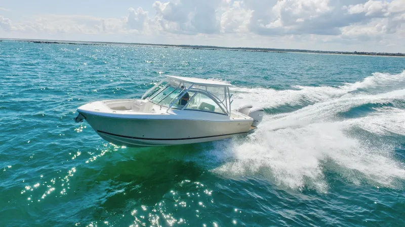 Slide: The Image of 2022 Albemarle 27 DC boat on water with dual engines, clear sky background. - 2