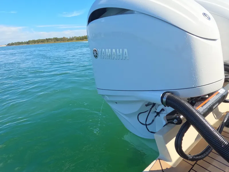 Slide: The Image of Twin Yamaha outboard engines on a 2022 Albemarle 27 DC boat, cruising in clear blue waters. - 22