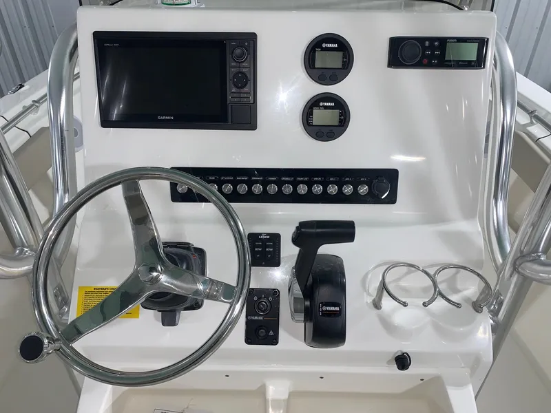 Slide: The Image of 2024 Key West 239 FS boat console with steering wheel, gauges, and controls. - 4