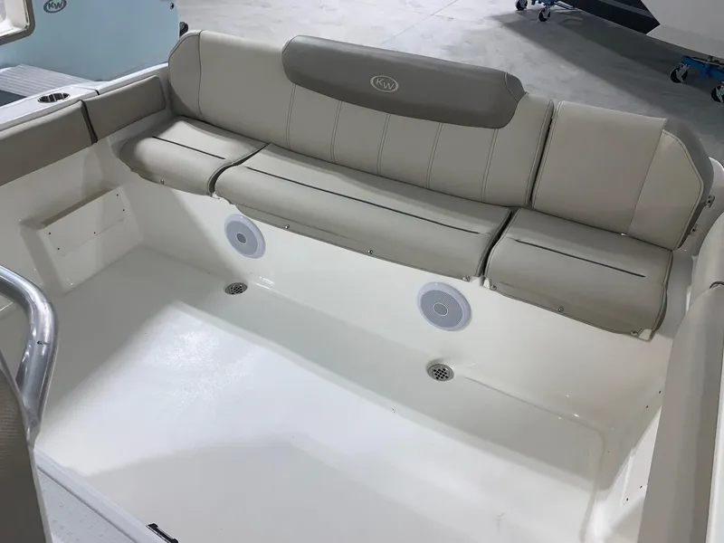 Slide: The Image of 2024 Key West 239 FS boat interior with cushioned seating and built-in speakers. - 7