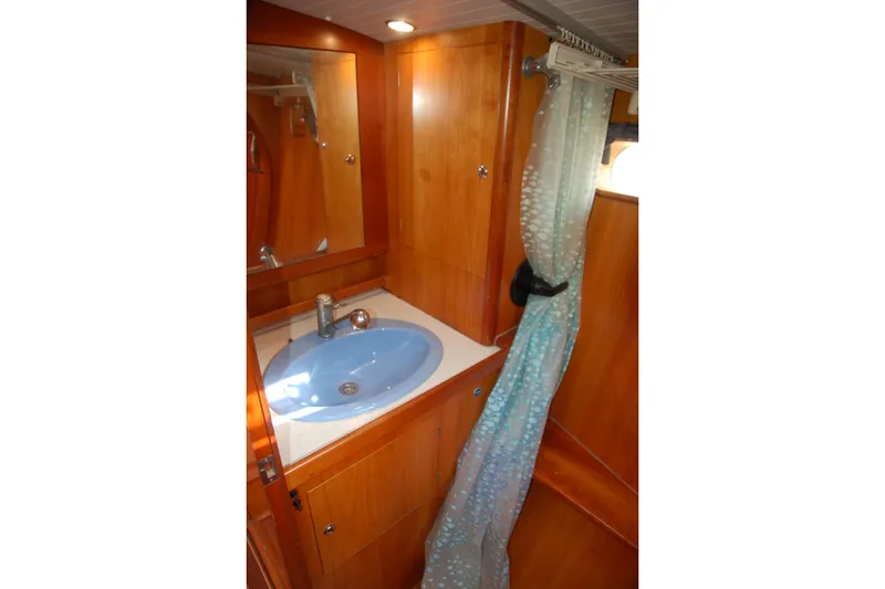 Slide: The Image of Bathroom interior of 2000 Garcia 48 Raised Salon yacht with blue sink and wooden cabinetry. - 64