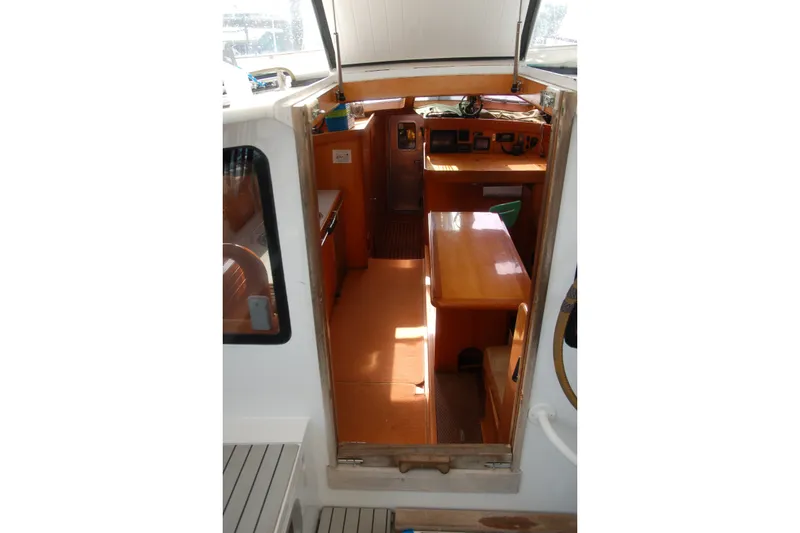 Slide: The Image of Interior view of 2000 Garcia 48 Raised Salon yacht, featuring wooden furnishings and navigation area. - 50