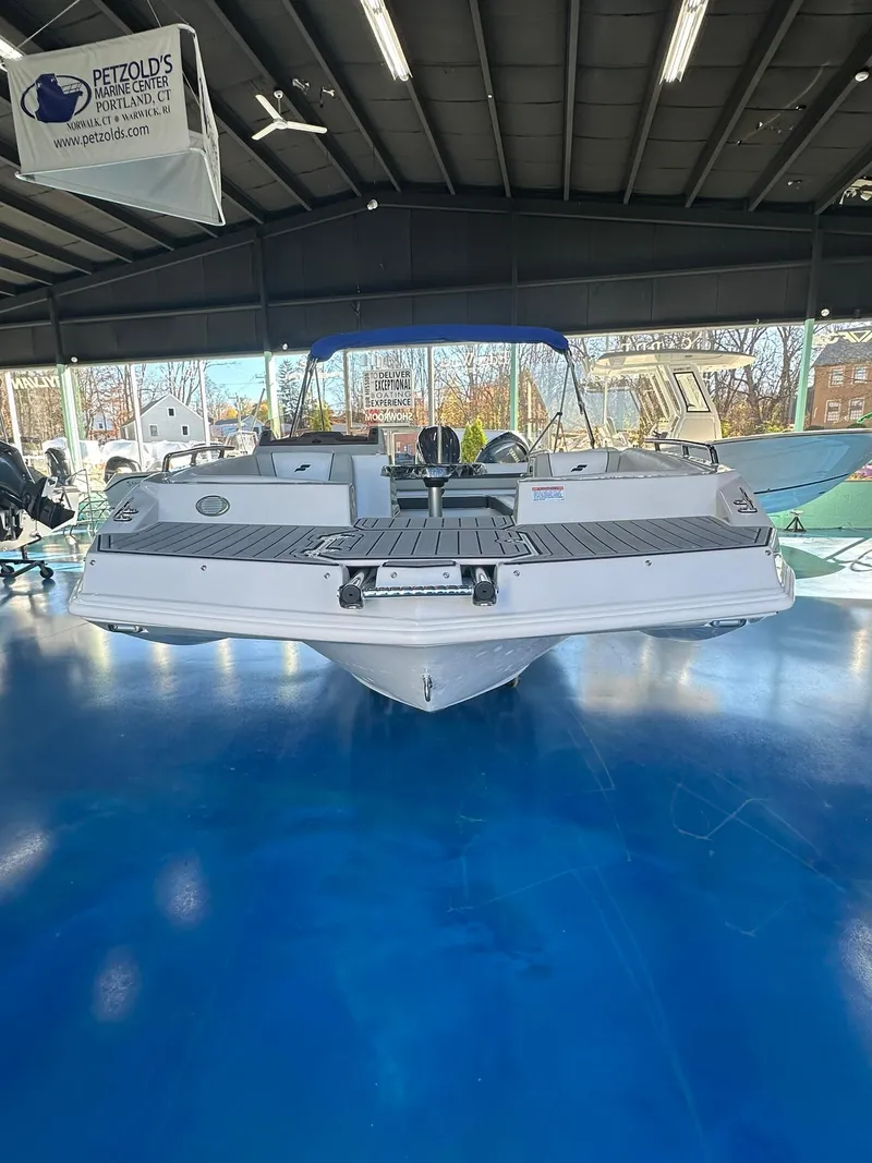 Slide: The Image of 2026 Starcraft SVX 191 OB boat with ladder on blue showroom floor. - 2