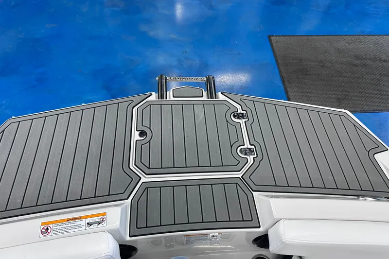Slide: The Image of 2026 Starcraft SVX 191 OB boat deck with gray non-slip surface, blue background. - 30