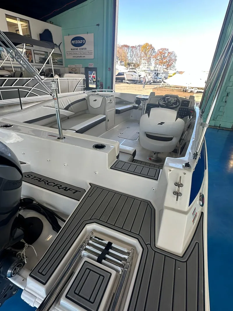 Slide: The Image of 2026 Starcraft SVX 191 OB boat interior with seating and outboard motors in showroom. - 8