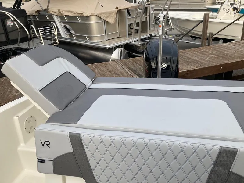 Slide: The Image of 2024 Bayliner VR5 boat with gray and white seating at a marina. - 5