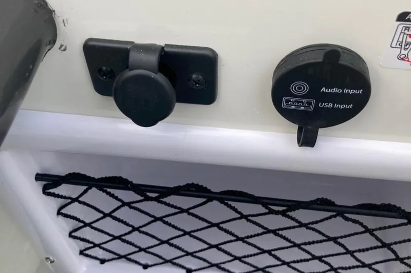 Slide: The Image of 2024 Bayliner VR5 audio and USB input ports with storage net. - 9