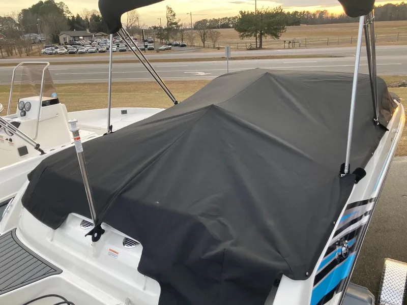 Slide: The Image of 2024 Bayliner VR5 boat with black cover in a parking lot. - 3