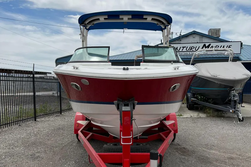 Slide: The Image of 2022 Regal LS2 Surf boat on a red trailer at a marine dealership. - 4